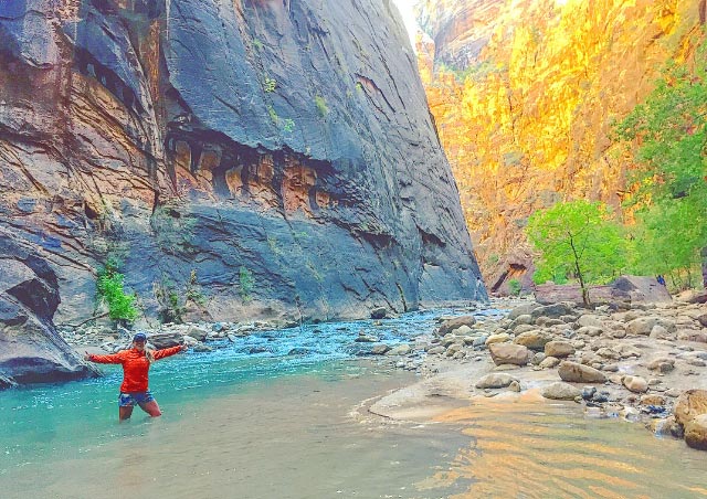 Embracing the icy cold water of the Narrows in Zion National Park.