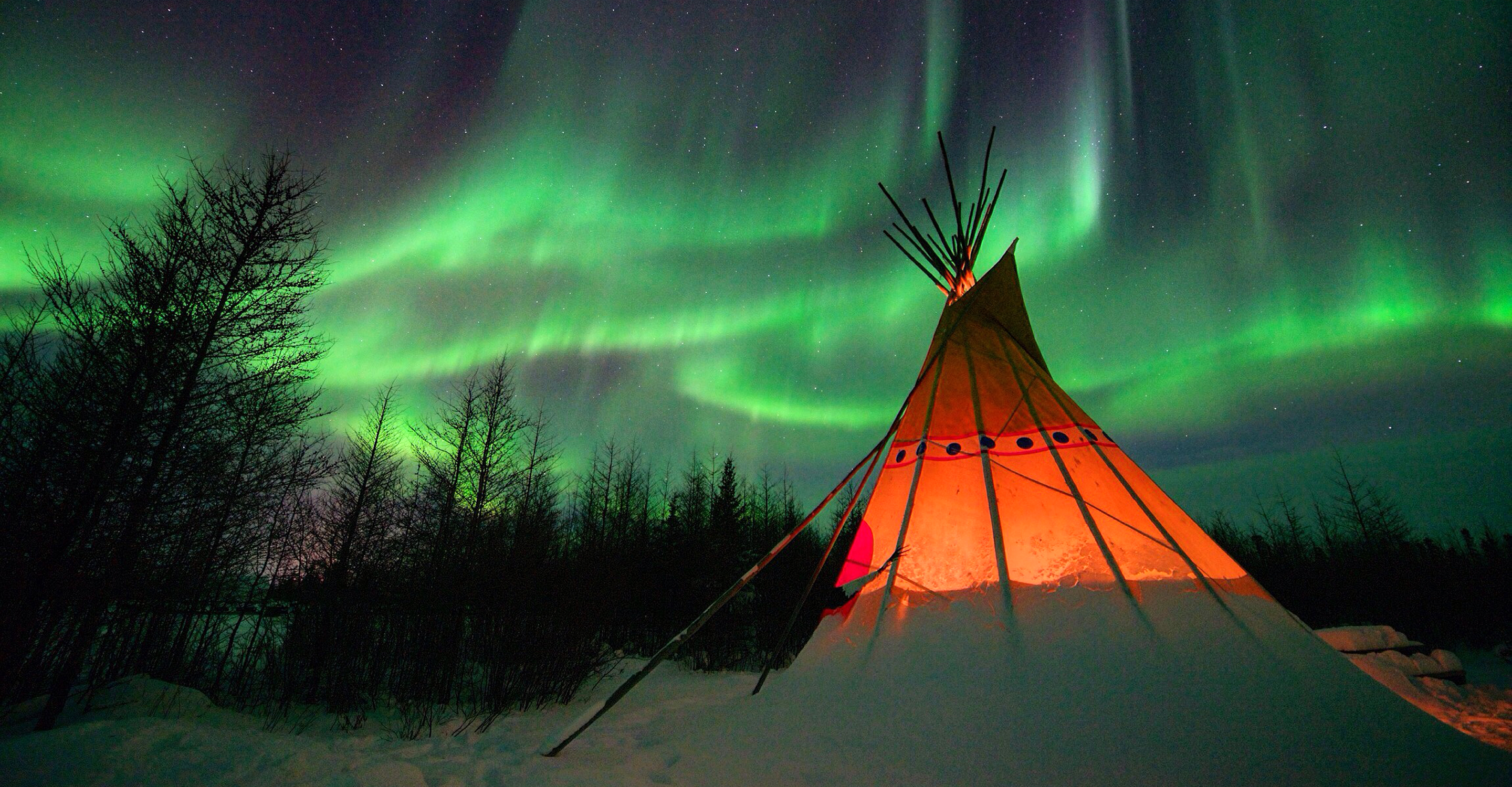 A teepee in the snow under the northern lights in Churchill, Manitoba, Canada;