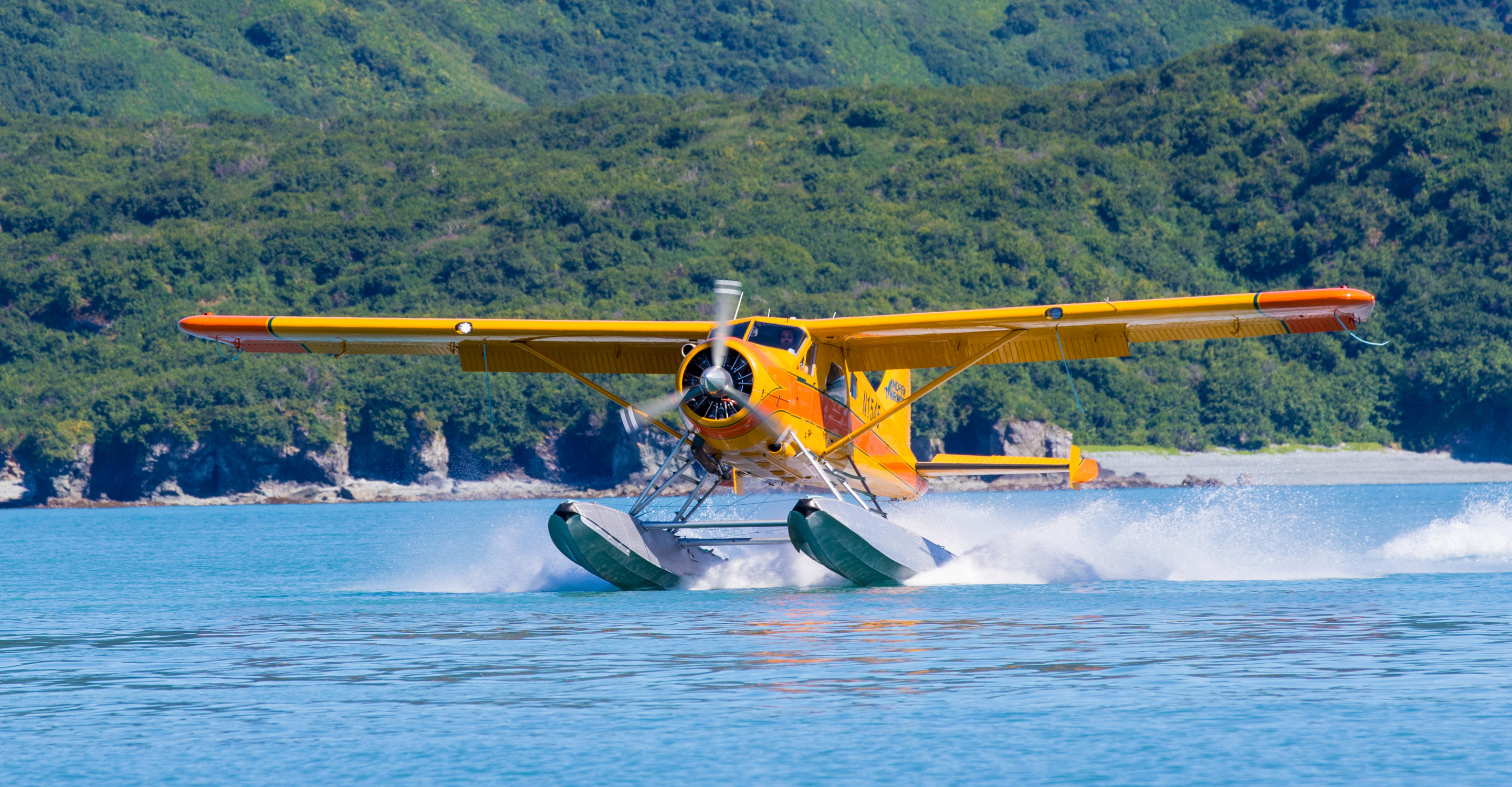 A float plane takes off from the water in Katmai National Park, Alaska, USA