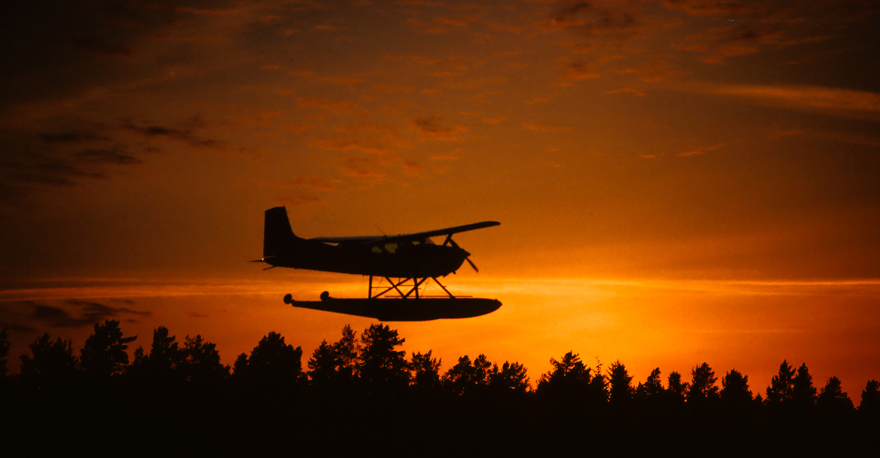 A silhouette of a sea plane at sunrise, Katmai National Park, Alaska, USA