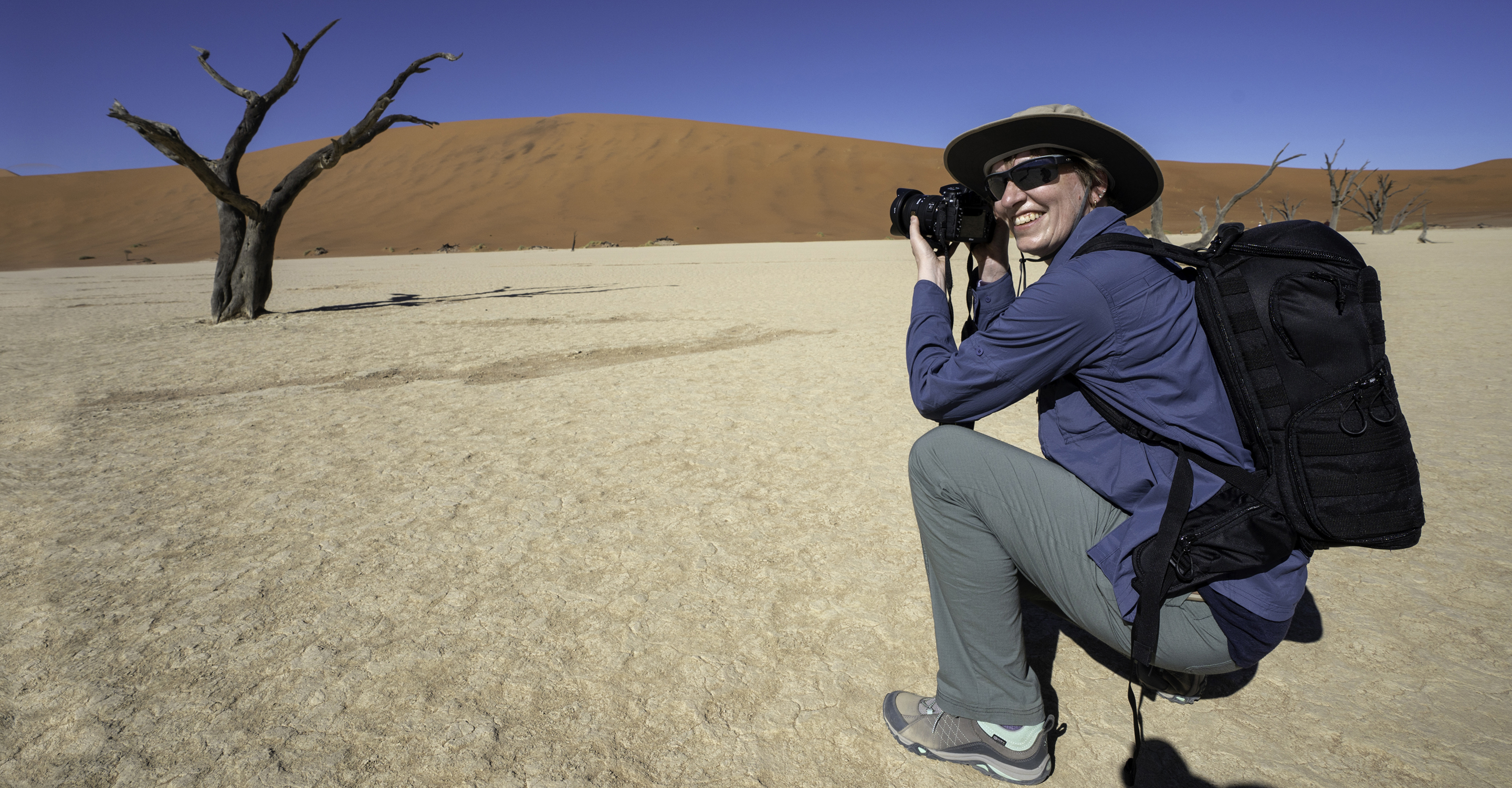 A a traveler photographs the sand dunes in Deal Vlei, Sossusvlei, Namibia