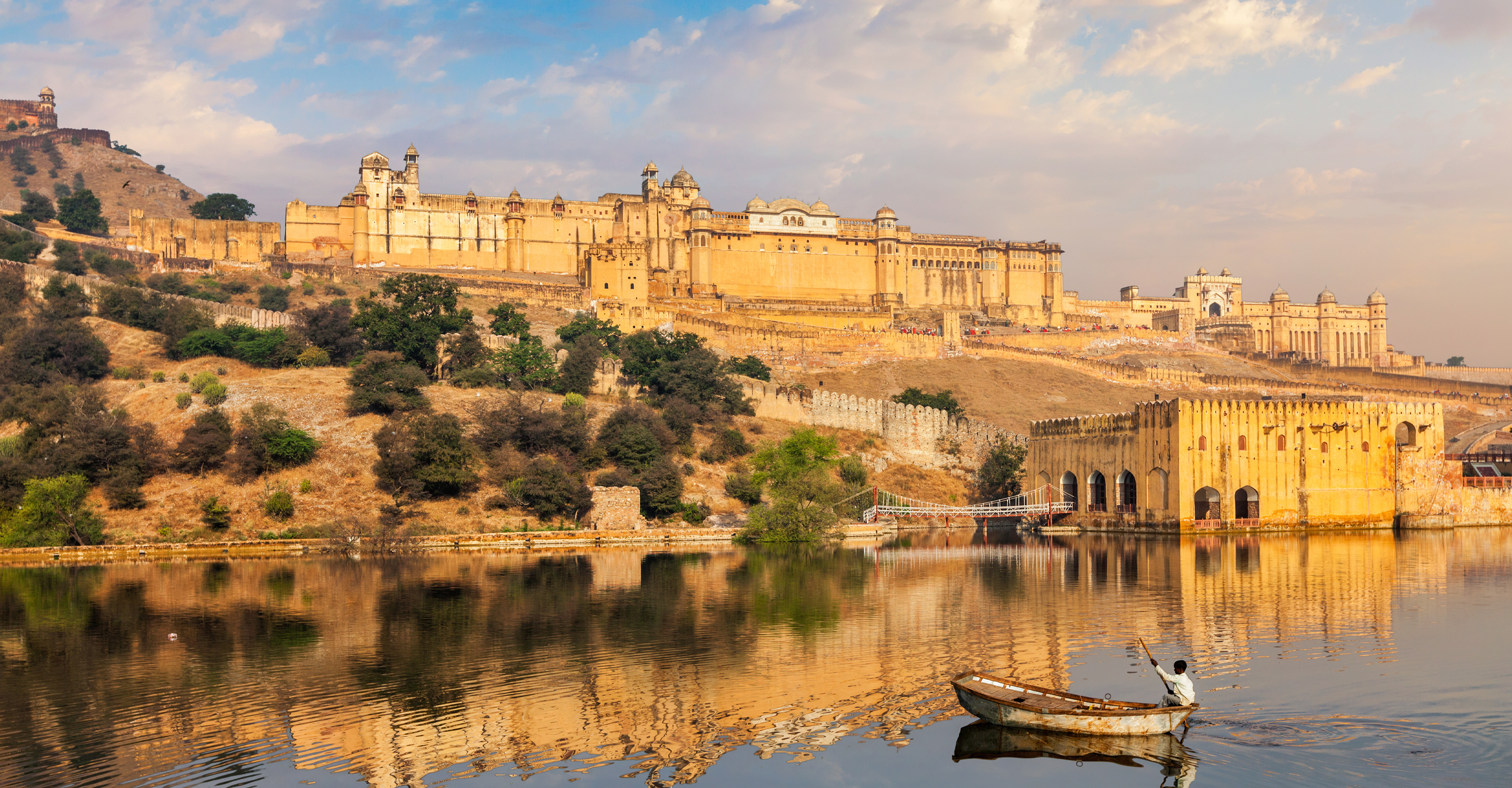 A man paddles a boat in front of the Amer sandstone fort in Jaipur, India