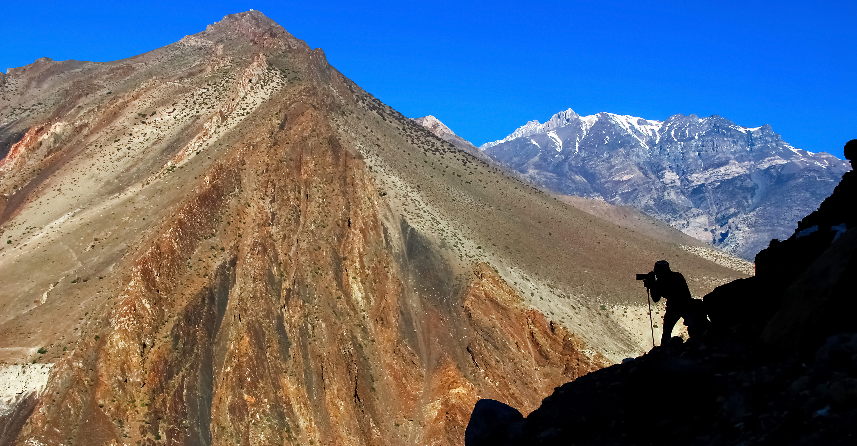 Silhouette of a traveler photographing the Himalayan mountains