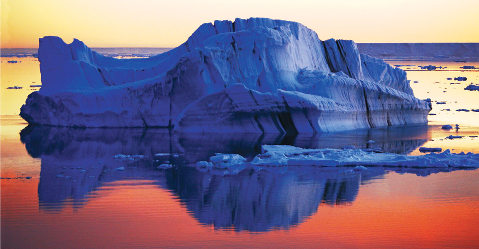 Sunset over the icebergs in the waters off Antarctica