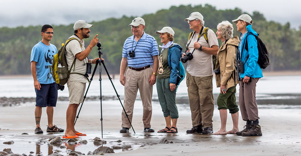 Travelers listen to their guide on the beach in Ballena Marine National Park, Costa Rica
