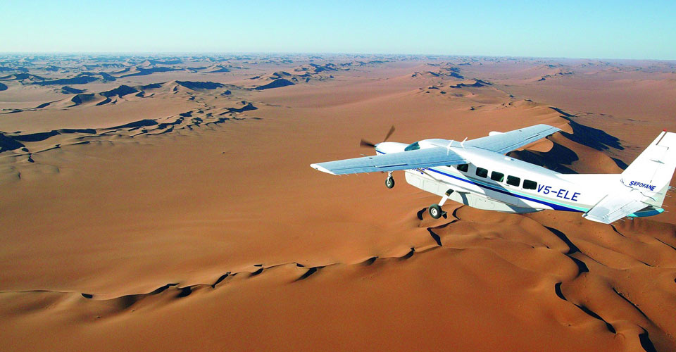 An aerial view of an airplane flying over the sand dunes of the Namib Desert, Namibia