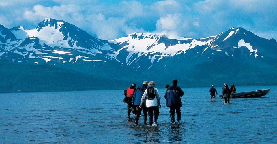 Travelers walk toward their boat in the bay, Katmai National Park, Alaska, USA