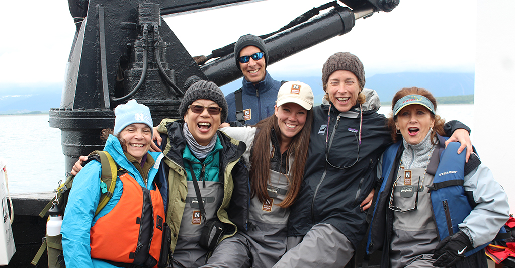 Travelers smile for a group photo aboard the Natural Habitat Ursus, Kodiak, Alaska, USA