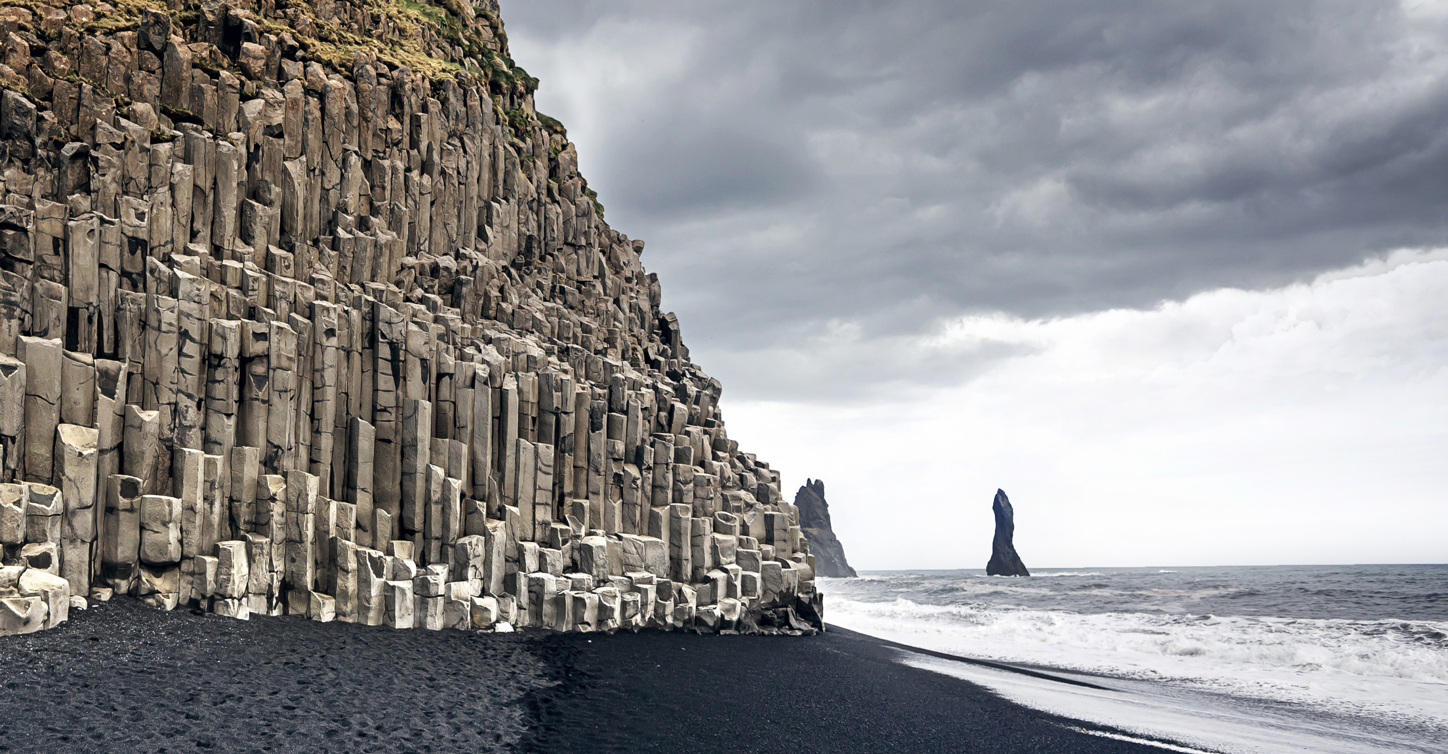The black sand beach of Reynisfjara and the mount Reynisfjall from the Dyrholaey promontory, Iceland, Europe.