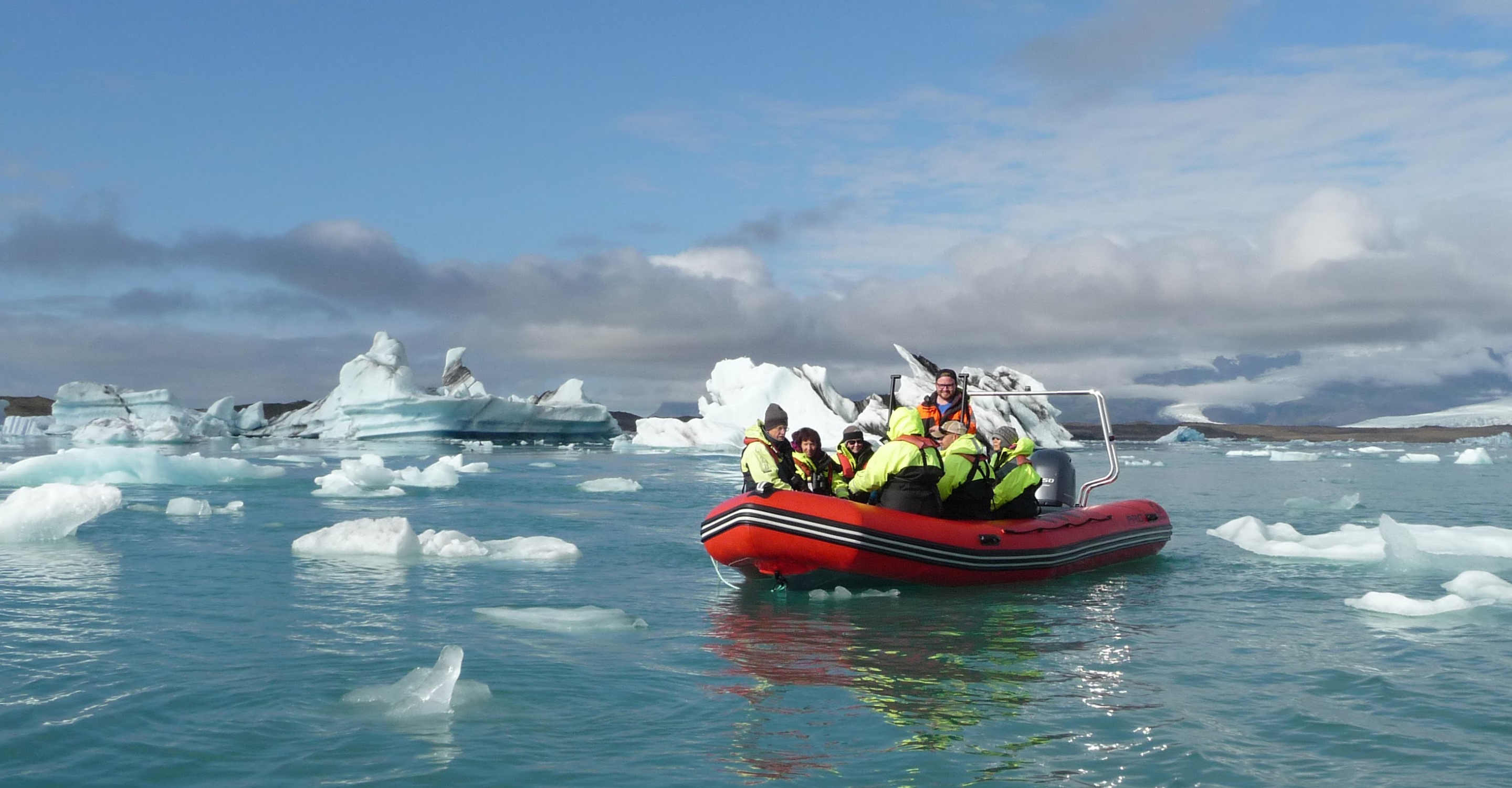Travelers on a private zodiac tour of Fjallsarlon Glacier Lagoon surrounded by icebergs, Iceland, Europe
