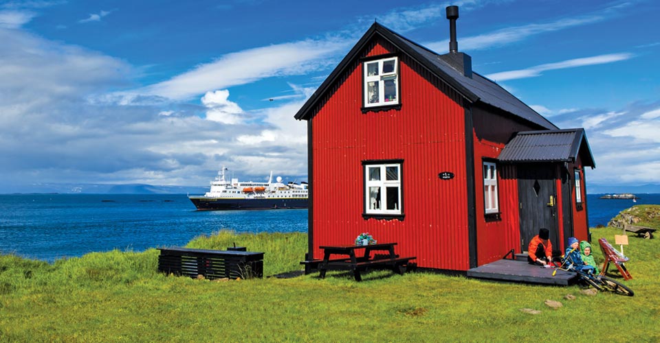 The National Geographic Explorer anchors behind a house on Flatey Island, Iceland