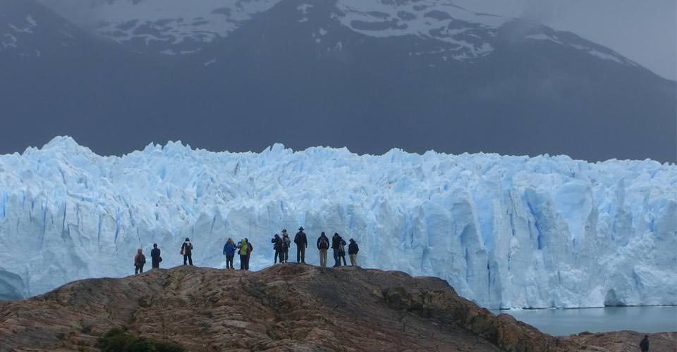 A group of travelers stand in front of a glacier, Perito Moreno Glacier, Los Glaciares National Park, Patagonia, Argentina