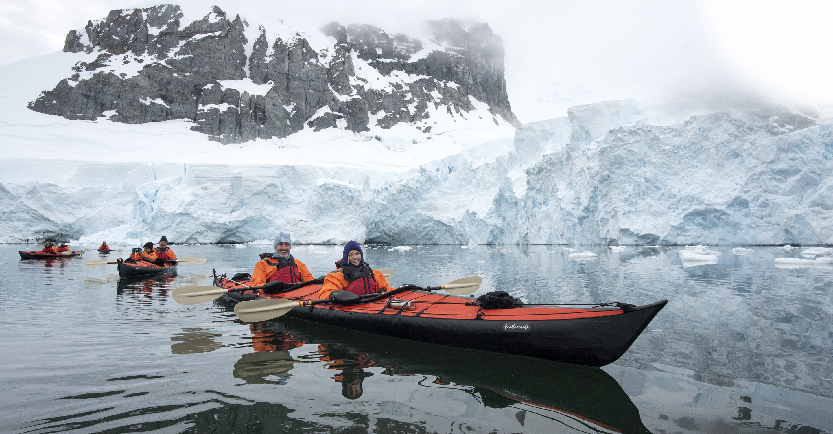 Natural Habitat Adventures travelers kayak near a glacier in Antarctica