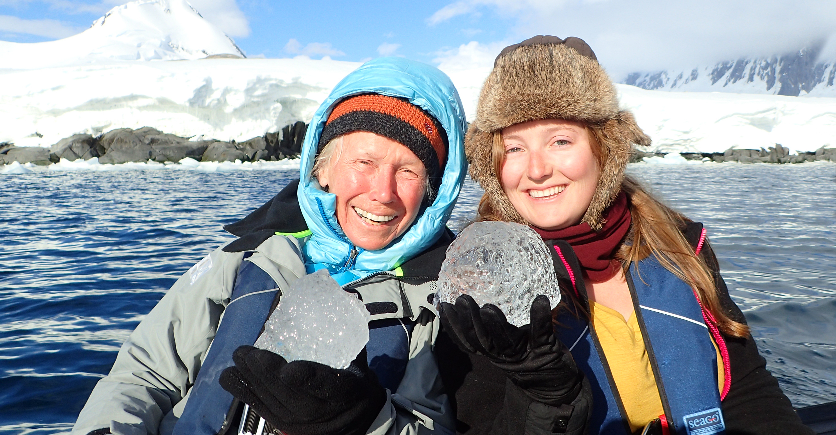 Travelers pose with ice from the waters off Antarctica
