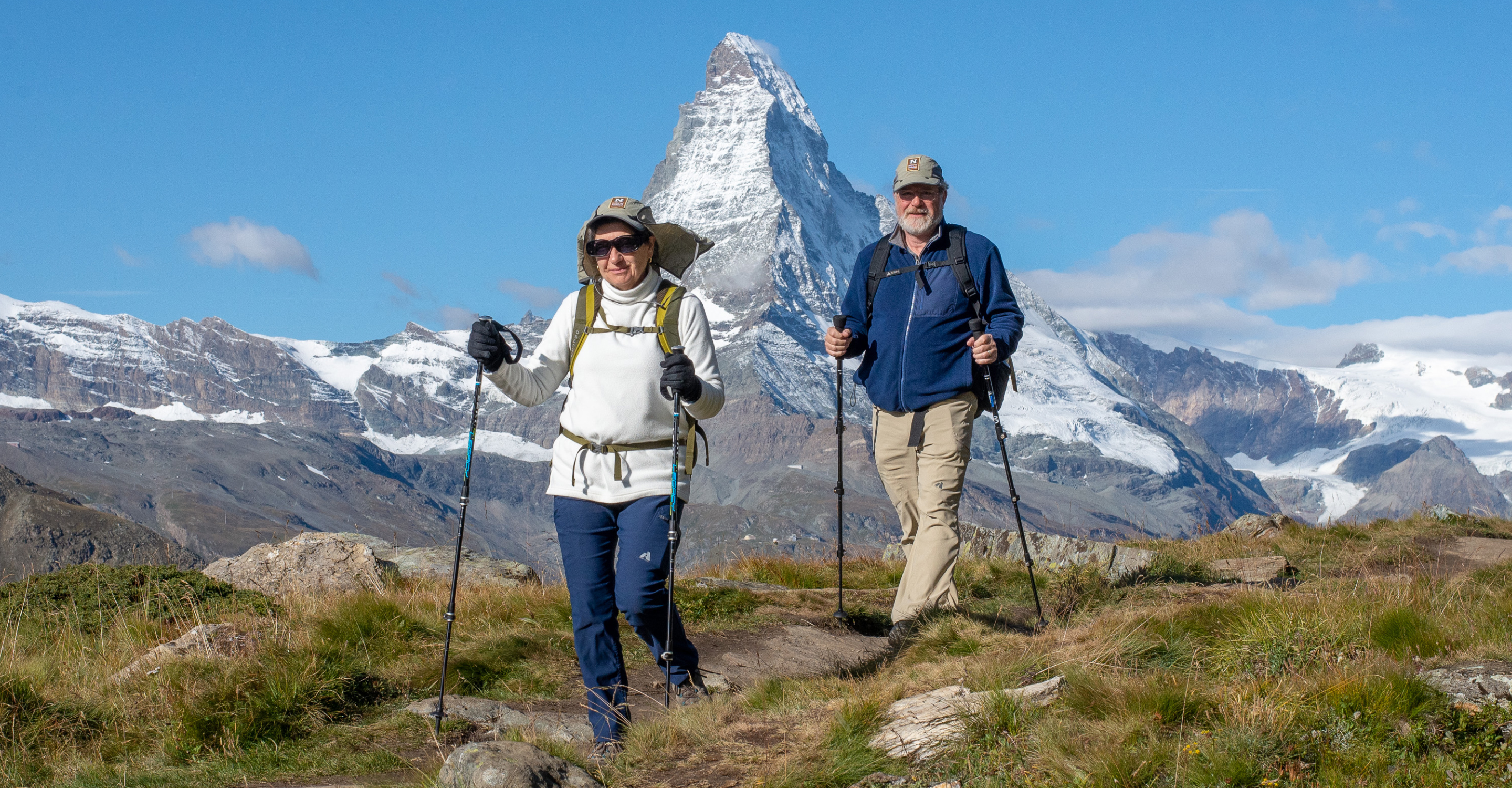 Two Natural Habitat Adventures travelers hiking in the Swiss Alps in front of the Matterhorn, Switzerland