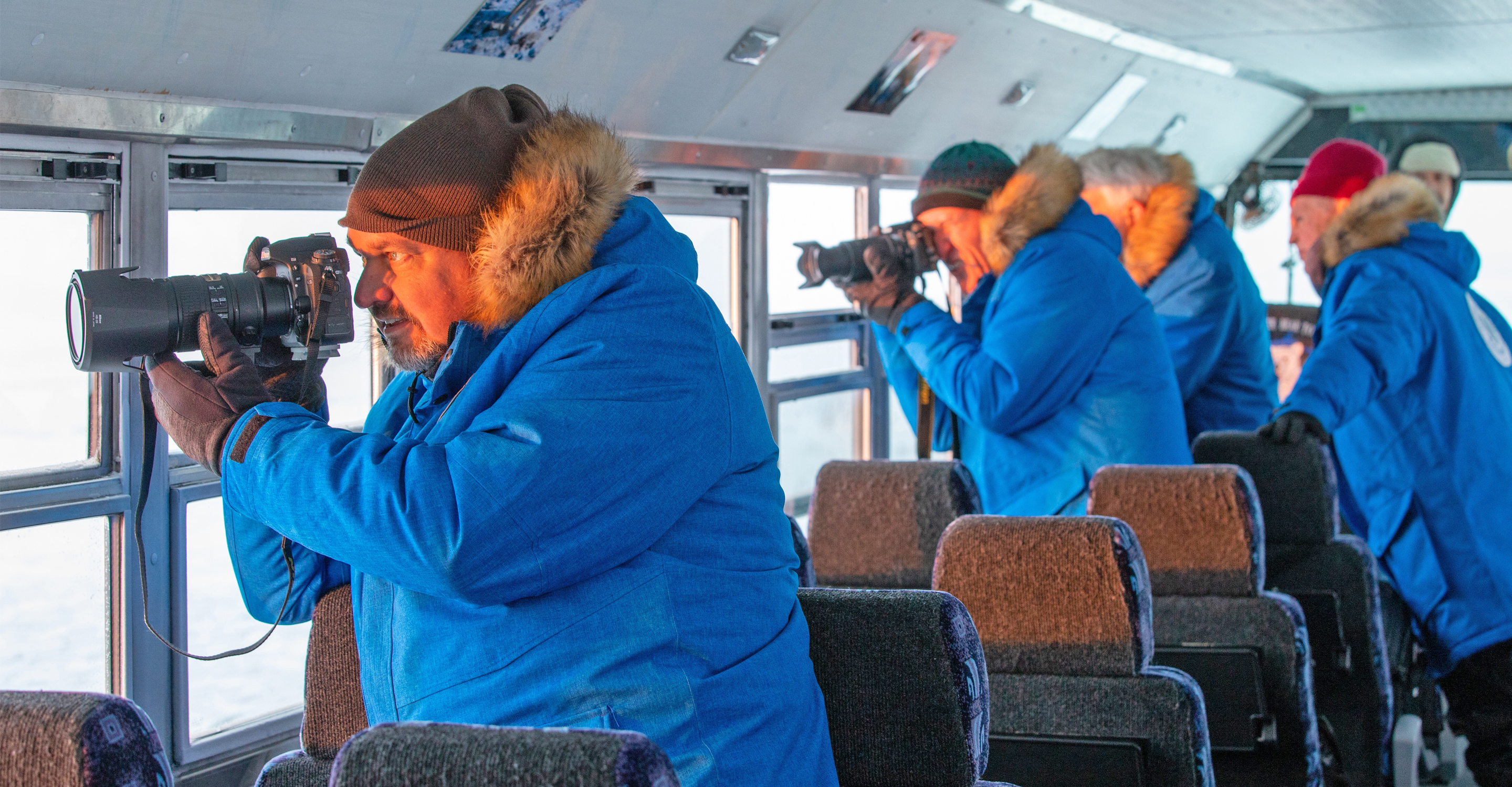 Natural Habitat Adventures travelers in a Polar Rover photograph the tundra from the windows, Churchill, Manitoba, Canada