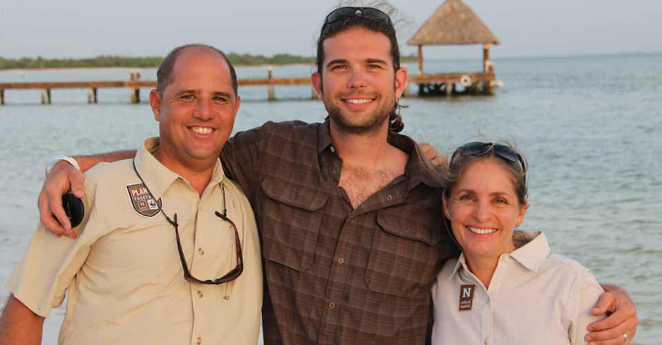 Two Natural Habitat Adventures guides and a traveler smile on the beach on Isla Holbox, Mexico