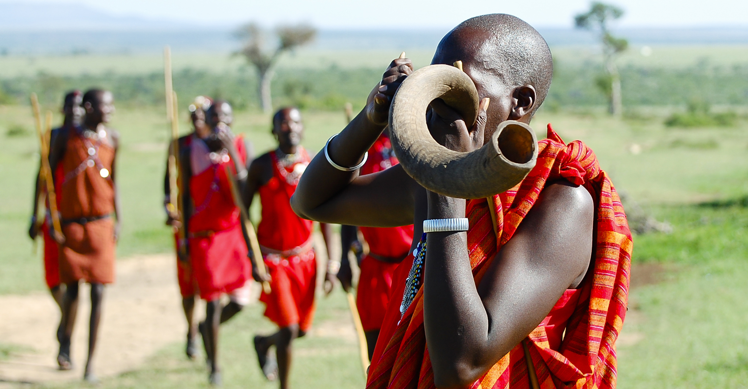 A Maasai warrior blows into a traditional horn during a demonstration in the Maasai Mara National Reserve, Kenya