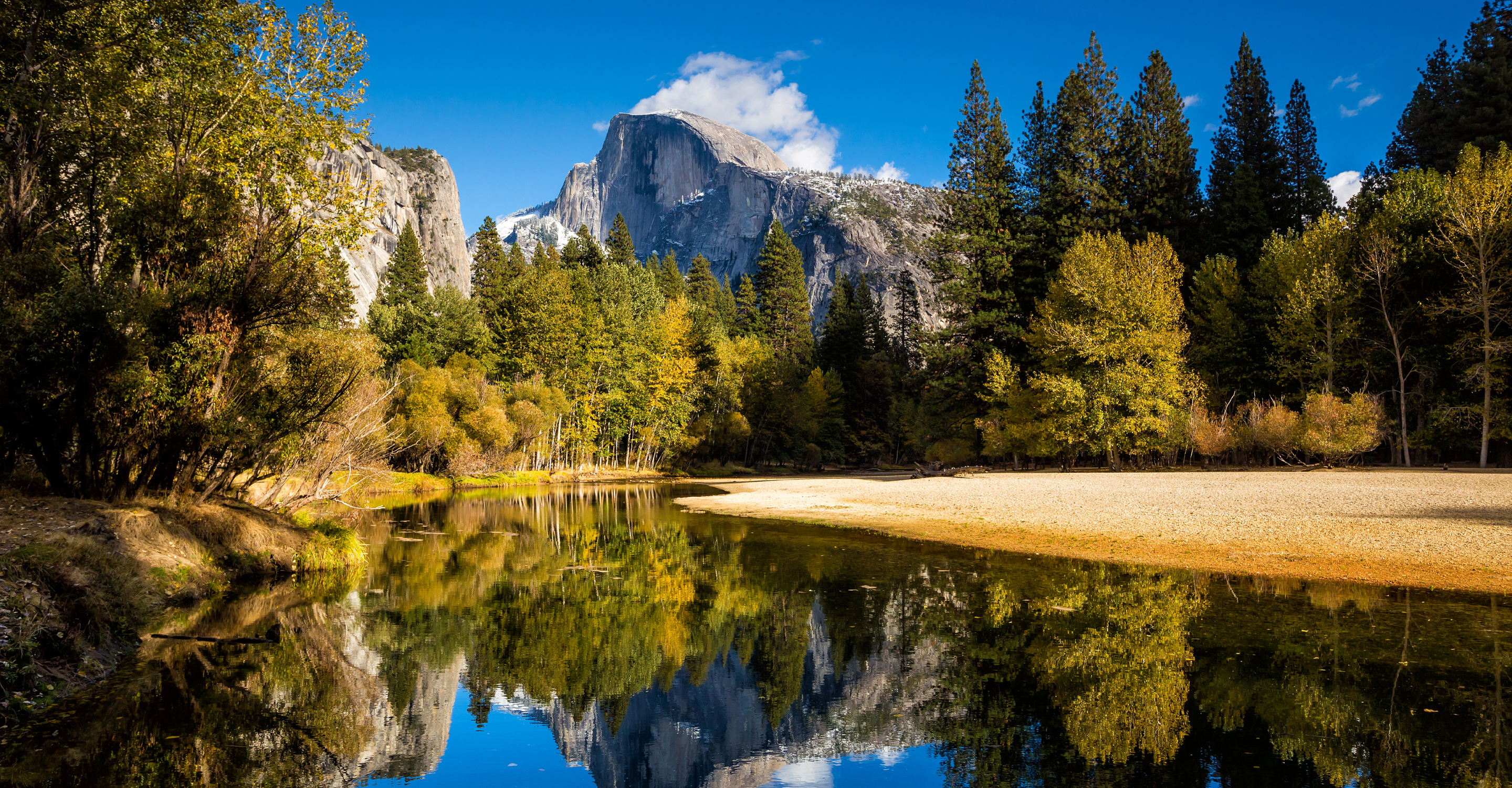 A lake sits in front of Half Dome mountain in Yosemite National Park, California, United States
